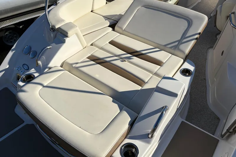 Slide: The Image of 2013 Chaparral 244 Sunesta boat interior with beige seating and cup holders. - 11