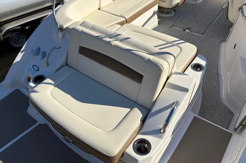 Slide: The Image of 2013 Chaparral 244 Sunesta boat seating area with cup holders and beige upholstery. - 12