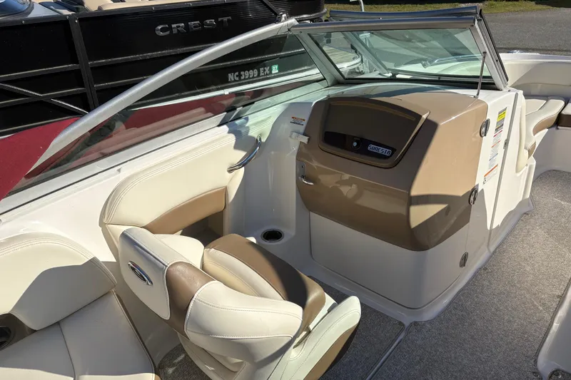 Slide: The Image of 2013 Chaparral 244 Sunesta boat interior with beige seating and dashboard. - 5