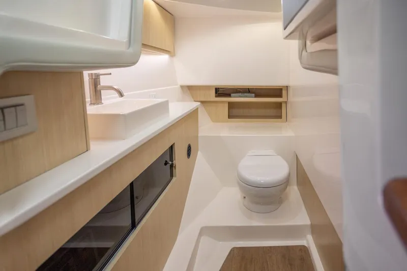 Slide: The Image of Manufacturer Provided Image: 2026 Regal LX36 boat bathroom with modern fixtures and light wood cabinetry. - 11