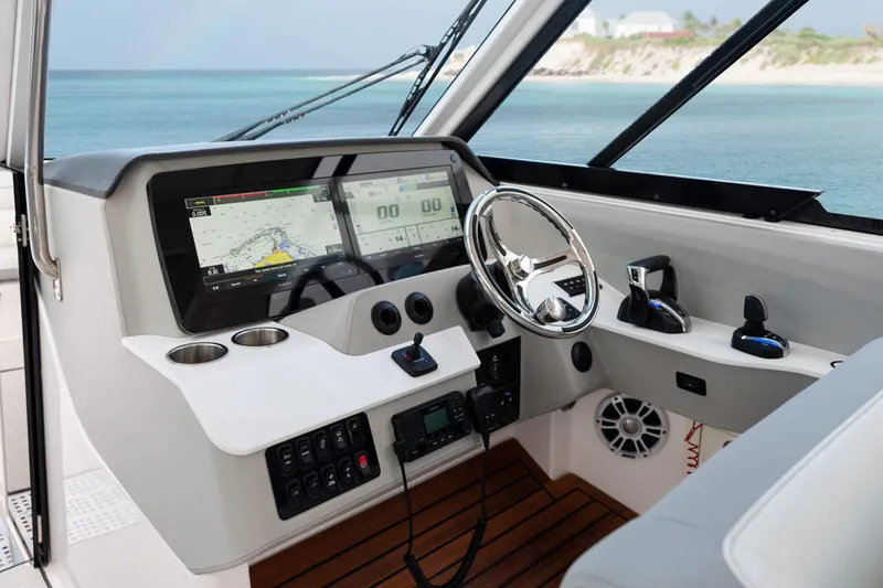 Slide: The Image of Manufacturer Provided Image: 2026 Regal LX36 boat cockpit with modern navigation system and steering wheel, overlooking serene ocean view. - 7