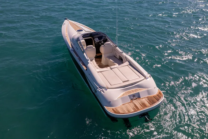 Slide: The Image of 2012 Hunton XRS 37 luxury speedboat on clear blue water, aerial view. - 2