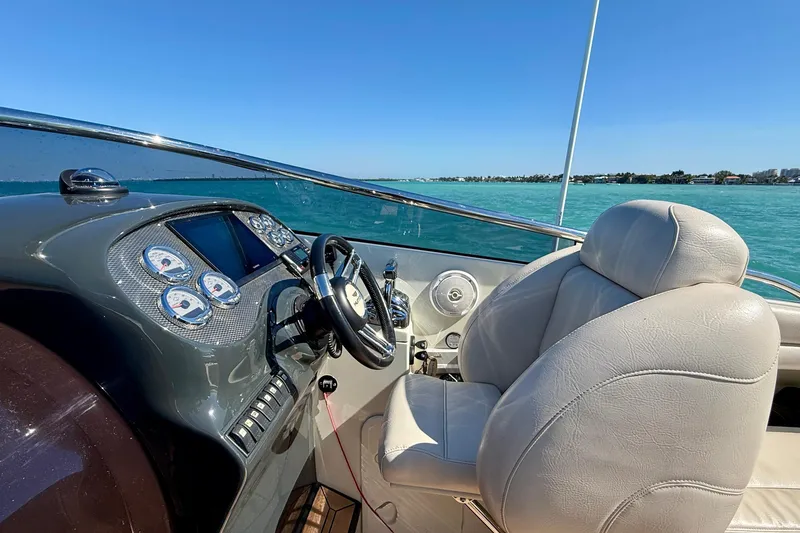 Slide: The Image of Cockpit of 2012 Hunton XRS 37 boat with steering wheel and gauges, overlooking blue water. - 7