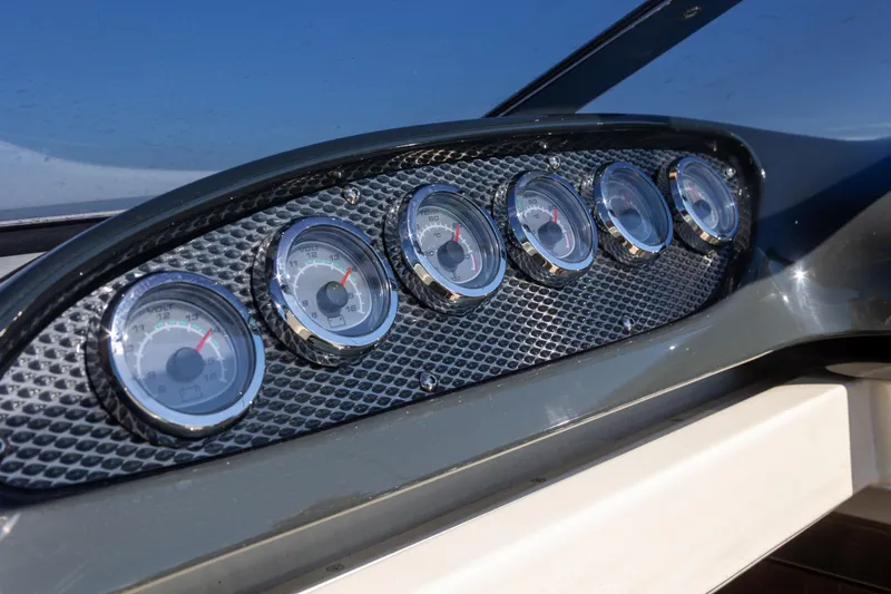 Slide: The Image of Dashboard gauges of a 2012 Hunton XRS 37 boat, featuring a sleek carbon fiber panel. - 8