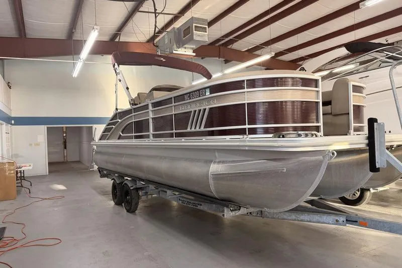 The Image of 2021 Bennington 23 LSB SPS pontoon boat in indoor storage on trailer. - 0