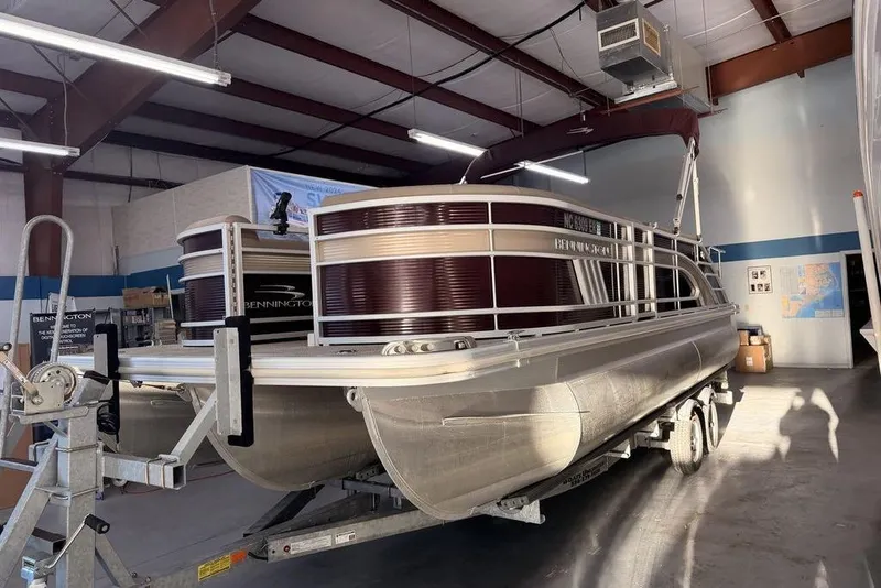 Slide: The Image of 2021 Bennington 23 LSB SPS pontoon boat in a warehouse setting. - 1