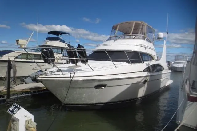 Slide: The Image of 2004 Carver 420 Mariner yacht docked at marina under clear blue sky. - 2