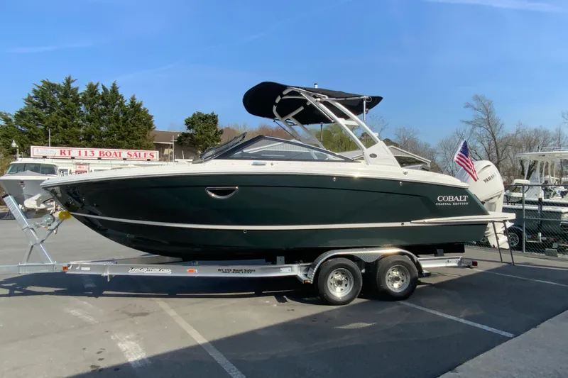 Slide: The Image of 2026 Cobalt R6 Outboard boat on trailer at dealership, featuring sleek design and American flag. - 13