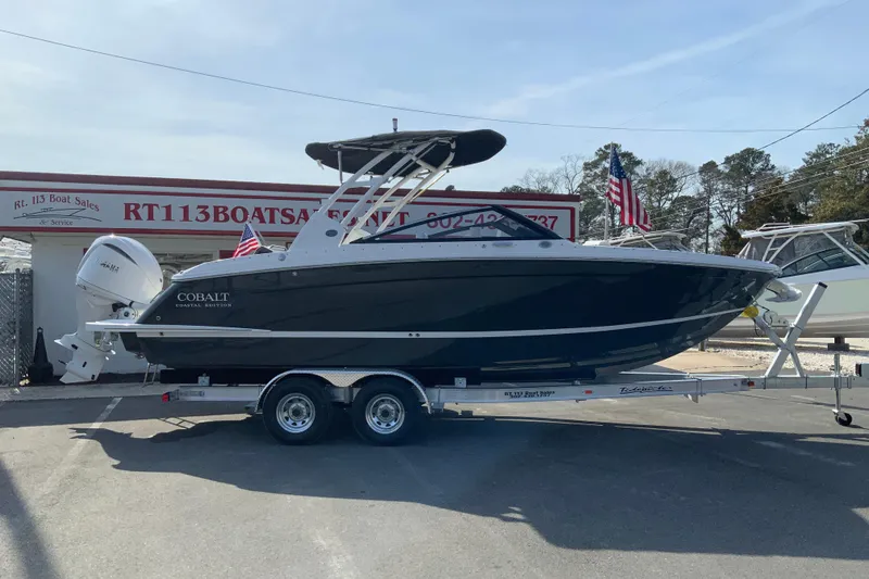 The Image of 2026 Cobalt R6 Outboard boat on trailer at dealership, featuring sleek design and modern outboard engine. - 3