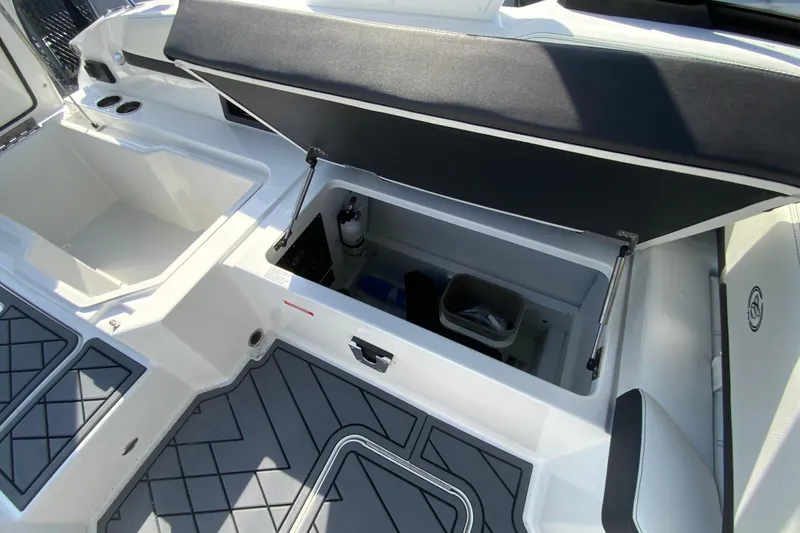 Slide: The Image of 2026 Cobalt R6 Outboard boat interior storage compartment with open lid and modern design. - 32