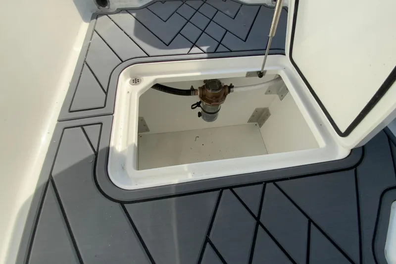 Slide: The Image of Open storage compartment on 2026 Cobalt R6 Outboard boat with gray flooring. - 48