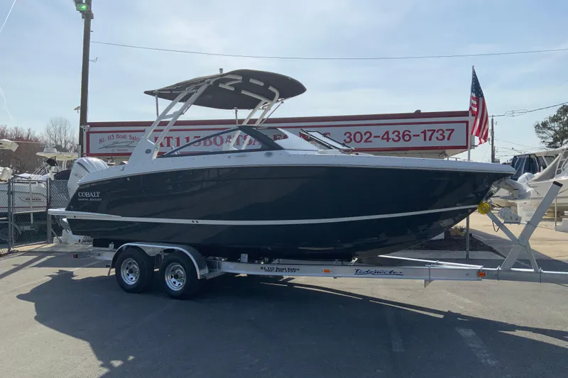 Slide: The Image of 2026 Cobalt R6 Outboard boat on trailer at dealership, American flag in background. - 5