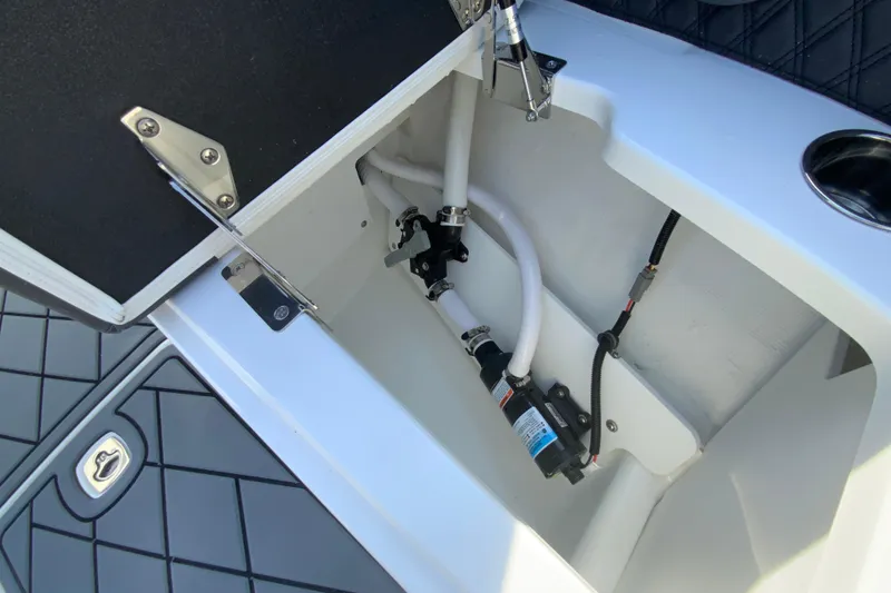 Slide: The Image of Open storage compartment in 2026 Cobalt R6 Outboard boat, showing internal components and wiring. - 53
