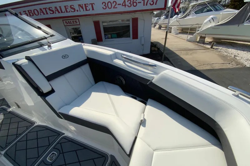 Slide: The Image of 2026 Cobalt R6 Outboard boat interior with white seating at a sales dock. - 54
