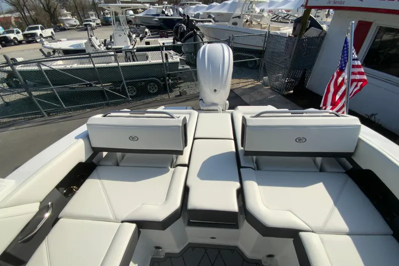 Slide: The Image of 2026 Cobalt R6 Outboard boat interior with seating, American flag, and marina background. - 66