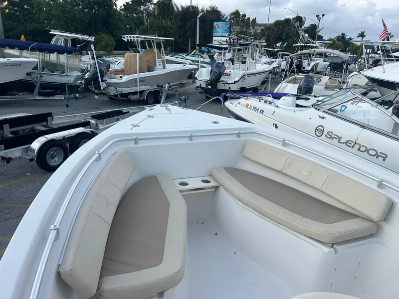 Slide: The Image of 2009 Cobia 216 Center Console boat with beige seating, docked among other boats. - 14