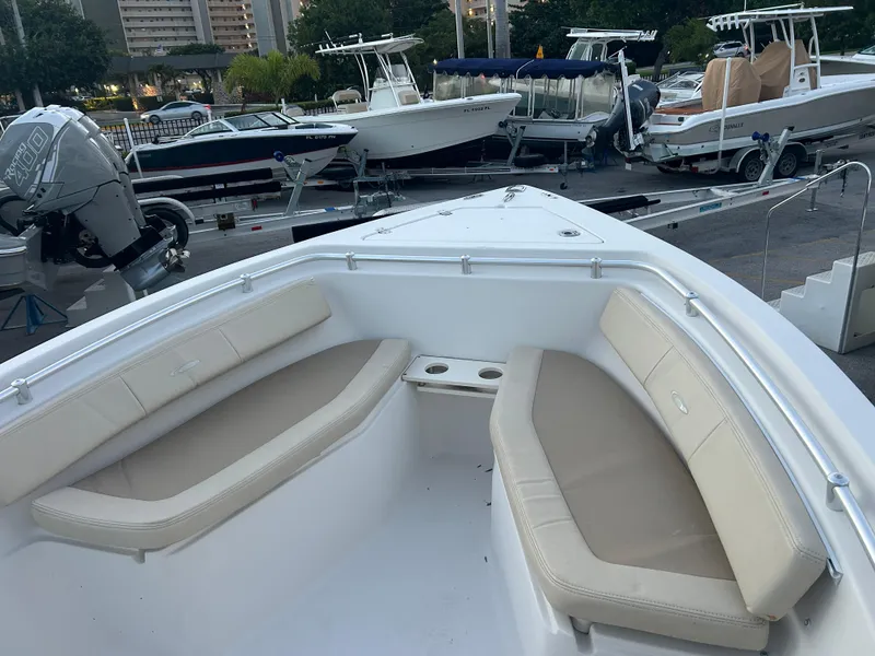 Slide: The Image of 2009 Cobia 216 Center Console boat with cushioned seating and cup holders, docked at marina. - 15