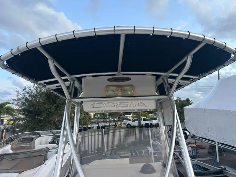 Slide: The Image of 2009 Cobia 216 Center Console boat with T-top in marina setting. - 19