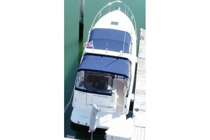 Slide: The Image of 2005 Rinker Fiesta Vee 270 boat docked with blue canopy and white hull. - 1