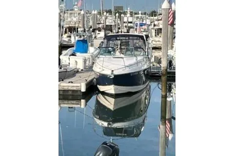 Slide: The Image of 2005 Rinker Fiesta Vee 270 boat docked in a marina, reflecting on calm water. - 11