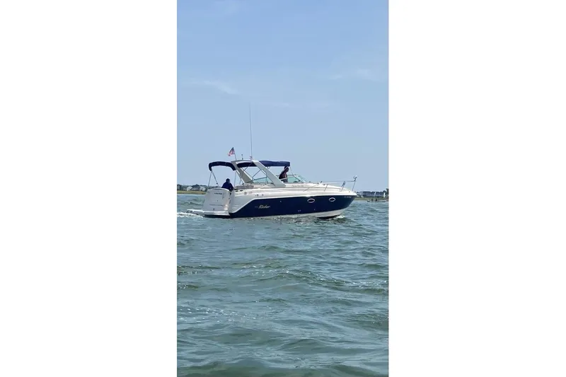 Slide: The Image of 2005 Rinker Fiesta Vee 270 boat cruising on open water under clear skies. - 14
