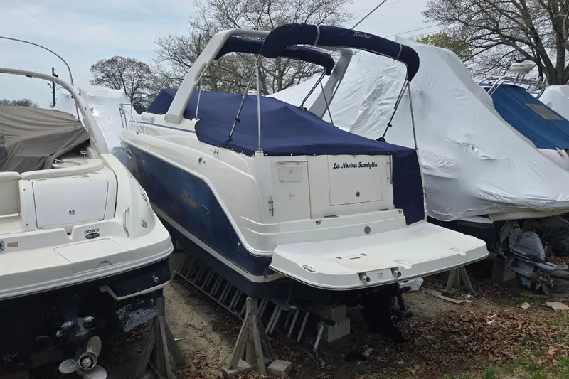 Slide: The Image of 2005 Rinker Fiesta Vee 270 boat in storage, covered and elevated on stands. - 15