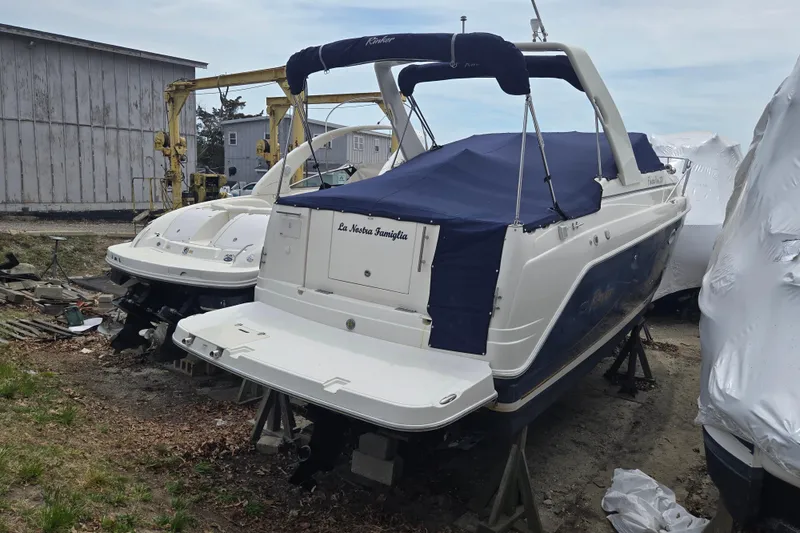 Slide: The Image of 2005 Rinker Fiesta Vee 270 boat with blue cover, docked outdoors. - 16