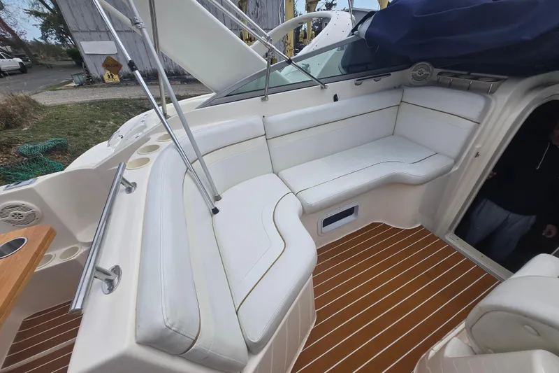 Slide: The Image of 2005 Rinker Fiesta Vee 270 boat interior with white seating and wood-patterned flooring. - 17