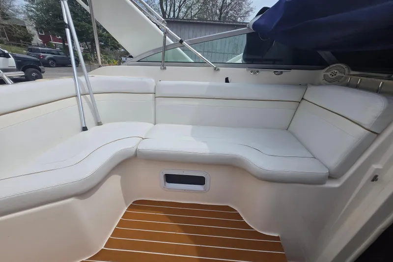 Slide: The Image of 2005 Rinker Fiesta Vee 270 boat interior with white seating and wood-style flooring. - 20