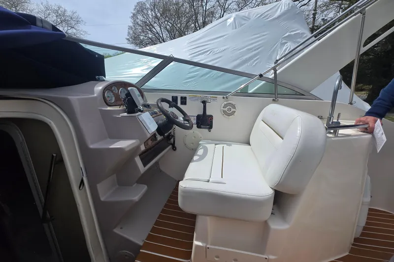 Slide: The Image of 2005 Rinker Fiesta Vee 270 boat cockpit with white seating and control panel. - 27