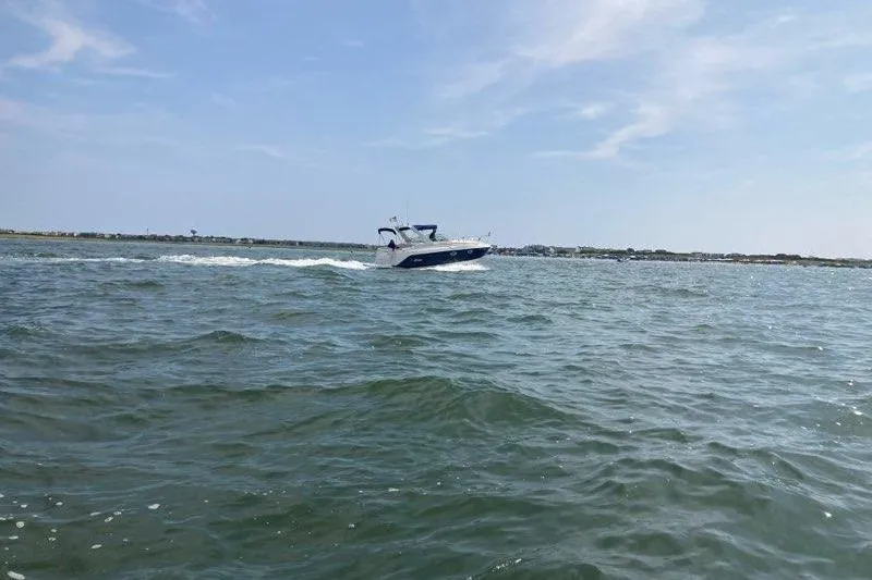 Slide: The Image of 2005 Rinker Fiesta Vee 270 cruising on open water under a clear sky. - 9