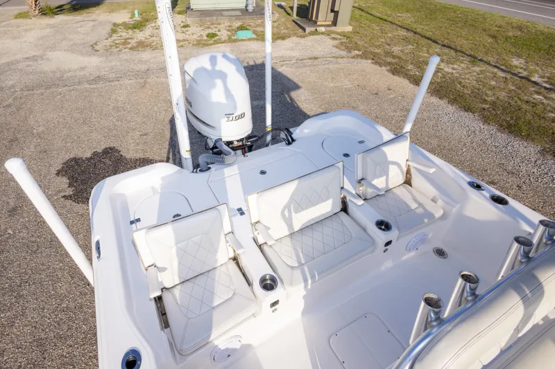 Slide: The Image of 2021 Blue Wave 2600 PureBay boat with seating and Yamaha 300 engine, parked on gravel. - 13