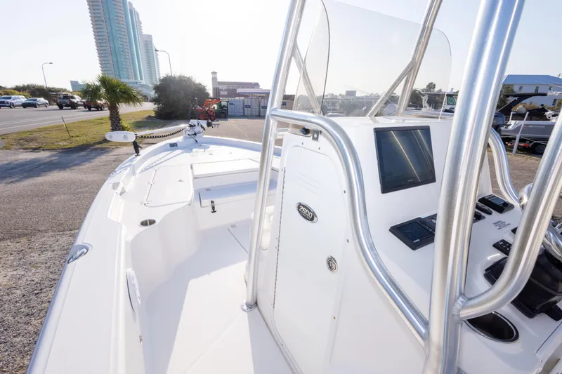 Slide: The Image of 2021 Blue Wave 2600 PureBay boat with sleek console and modern controls, parked near a road. - 19