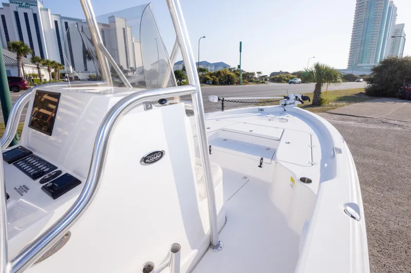 Slide: The Image of 2021 Blue Wave 2600 PureBay boat with sleek design, parked near modern buildings. - 20