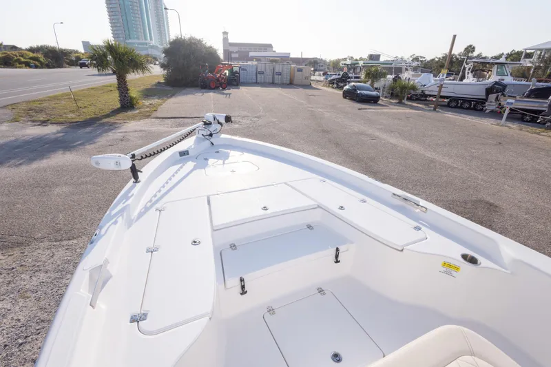 Slide: The Image of 2021 Blue Wave 2600 PureBay boat parked near marina with palm trees and buildings. - 22