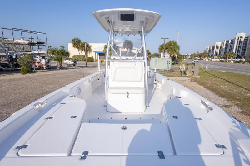 Slide: The Image of 2021 Blue Wave 2600 PureBay boat with center console, parked near palm trees and buildings. - 26