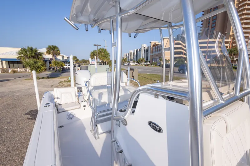 Slide: The Image of 2021 Blue Wave 2600 PureBay boat with sleek design, parked near palm trees and buildings. - 30