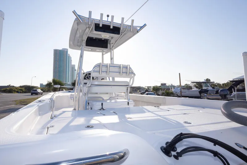 Slide: The Image of 2021 Blue Wave 2600 PureBay boat with T-top, docked near modern buildings. - 36