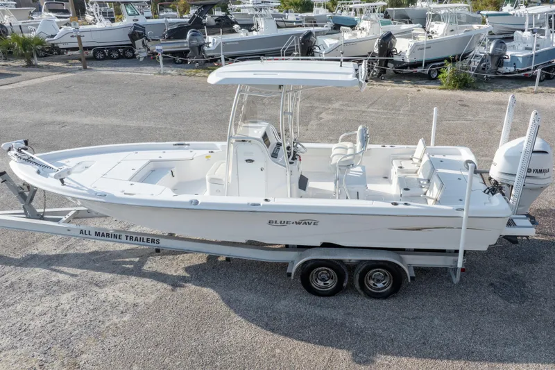 Slide: The Image of 2021 Blue Wave 2600 PureBay boat on trailer, parked in a marina with other boats. - 43