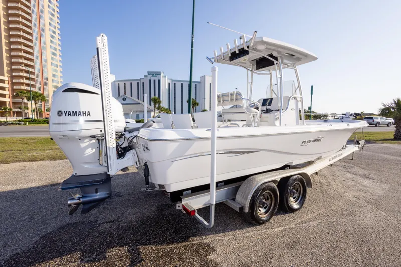 Slide: The Image of 2021 Blue Wave 2600 PureBay boat with Yamaha engine on a trailer, parked near buildings. - 5