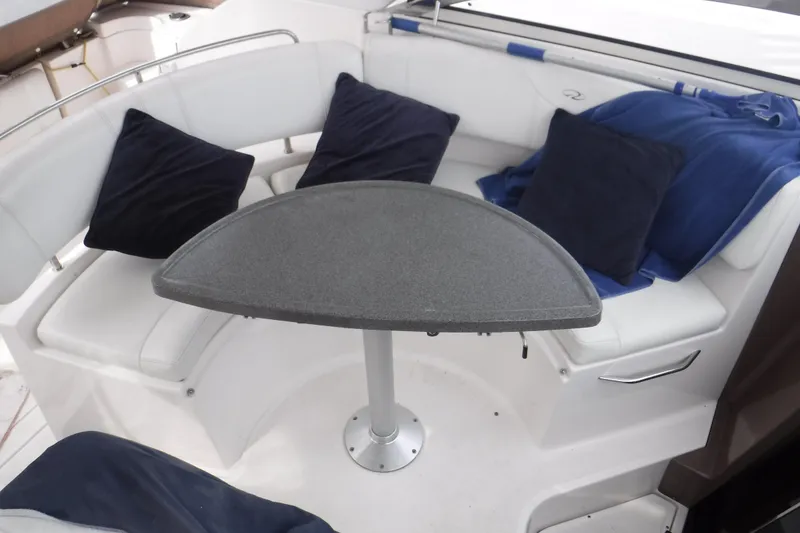 Slide: The Image of 2006 Regal Commodore 3560 IO boat interior with white seating and black cushions. - 10