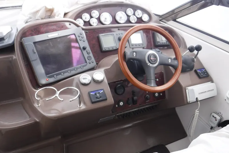 Slide: The Image of 2006 Regal Commodore 3560 IO boat dashboard with steering wheel and navigation instruments. - 2