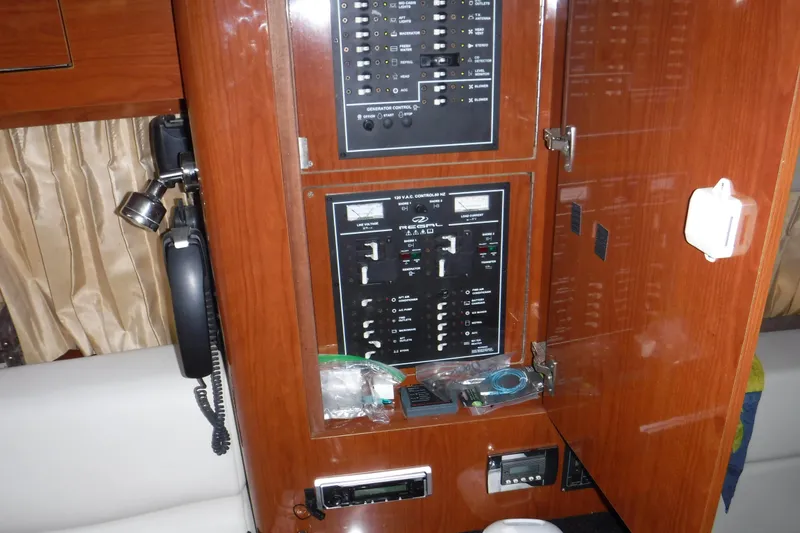Slide: The Image of Control panel inside a 2006 Regal Commodore 3560 IO yacht, featuring switches and a phone. - 24