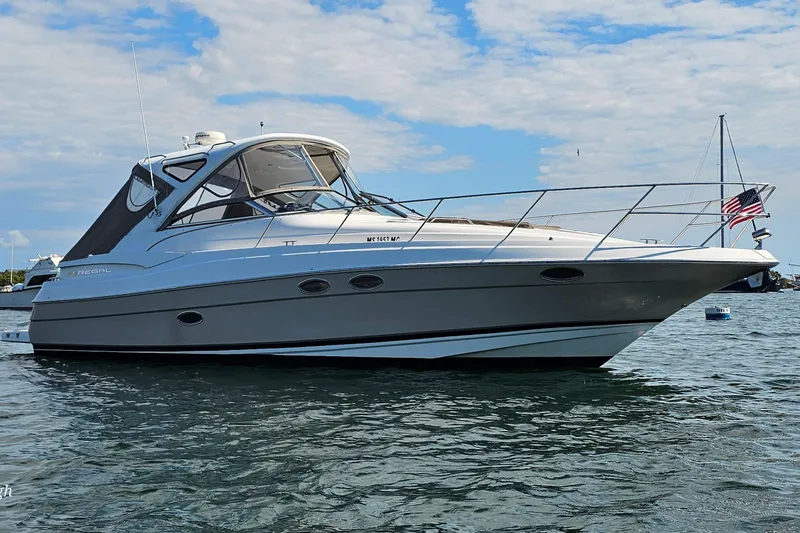 Slide: The Image of 2006 Regal Commodore 3560 yacht on water, clear sky, American flag. - 28