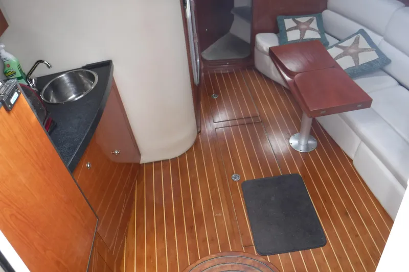 Slide: The Image of Interior of 2006 Regal Commodore 3560 IO yacht with wood flooring and compact kitchenette. - 3