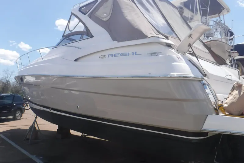 Slide: The Image of 2006 Regal Commodore 3560 yacht on dry dock under a clear blue sky. - 33