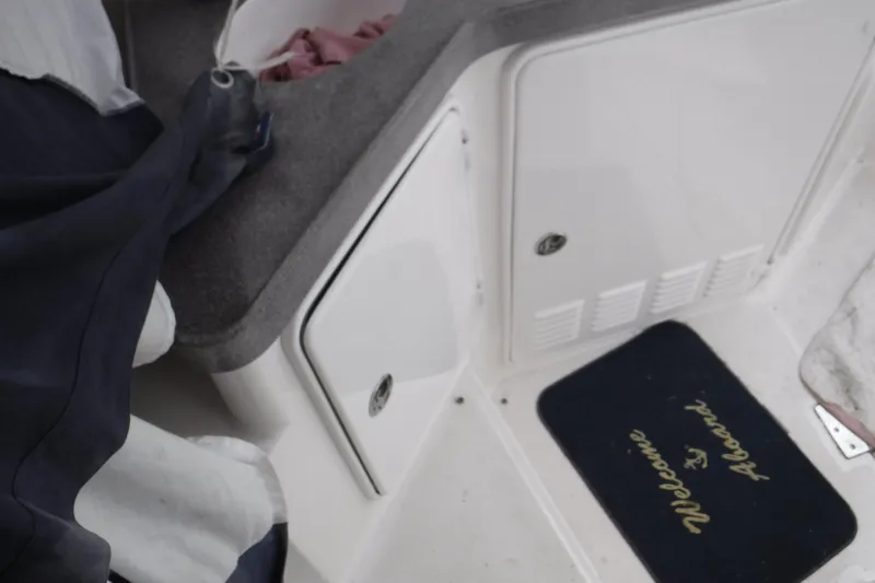 Slide: The Image of 2006 Regal Commodore 3560 IO boat interior with "Welcome Aboard" mat and storage compartments. - 8