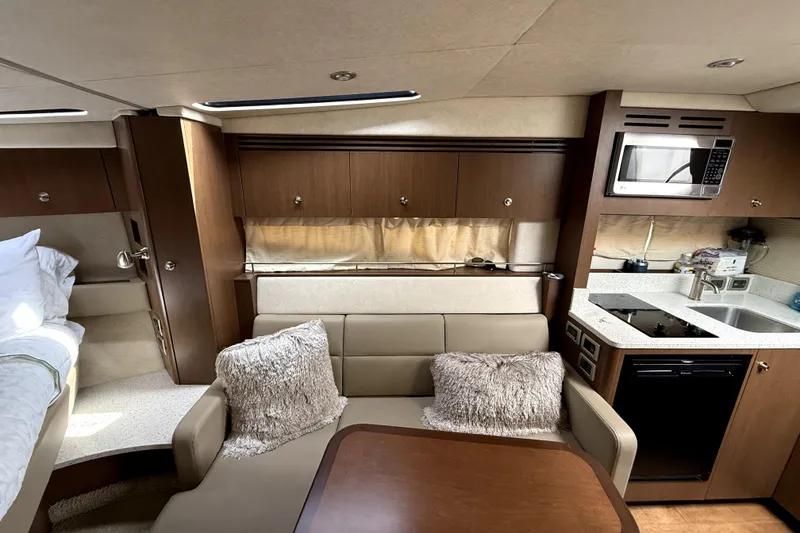 Slide: The Image of Luxurious interior of 2013 Sea Ray Sundancer 350 with beige seating and wooden table. - 10
