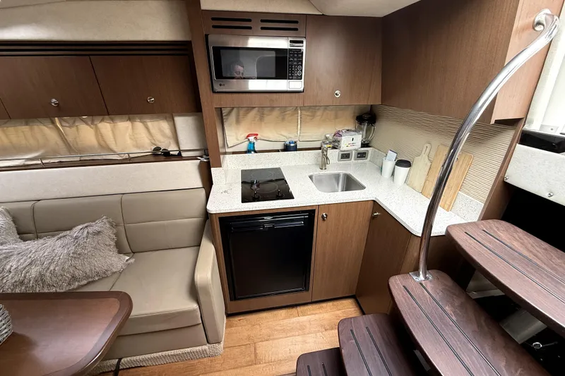 Slide: The Image of Interior of 2013 Sea Ray Sundancer 350 with beige seating and wooden table. - 9
