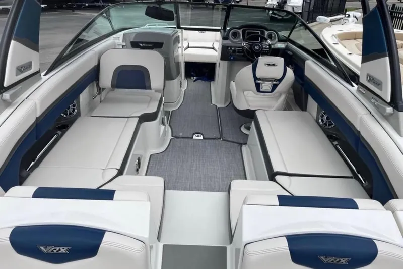 Slide: The Image of 2016 Chaparral Vortex 243 VRX boat interior with blue and white seating and modern dashboard. - 2